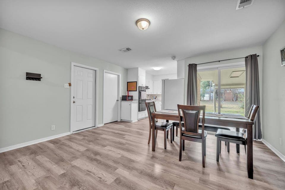 Dining area looking at a large, fenced backyard. 