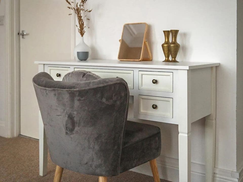 Get ready at the dressing table with a padded chair and mirror.