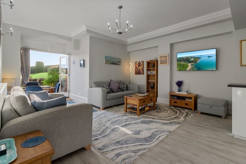 Bright open-plan lounge with comfy seating and Smart TV