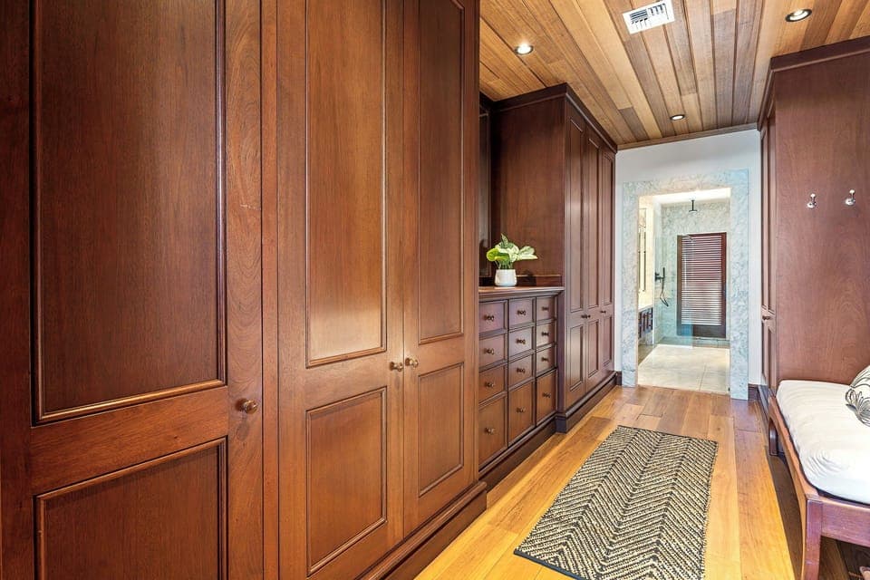 Your spacious walk-in closet offers abundant storage with custom wood cabinetry and warm lighting for organizing your vacation wardrobe in style.