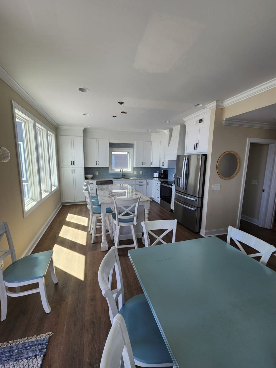 Your bright kitchen features modern appliances, elegant white cabinetry, and warm wood floors perfect for preparing meals.
