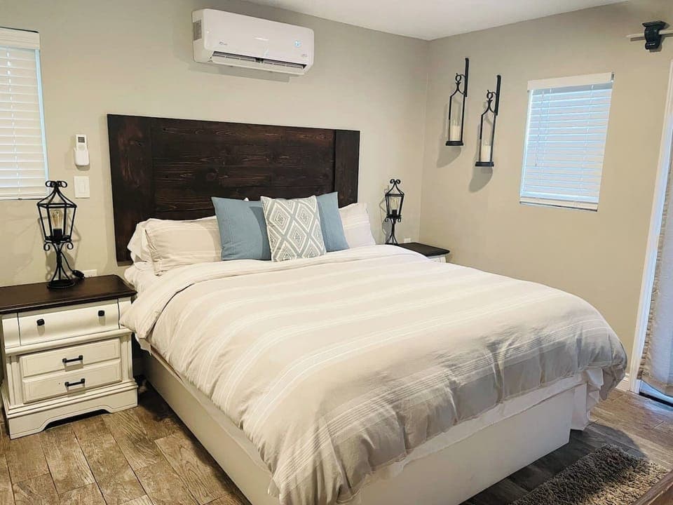 This gorgeous guest room is a private oasis, featuring a stunning dark wood headboard, stylish distressed nightstands, and soft, high-quality linens. Enjoy customized comfort with the dedicated AC/heating unit and charming ambient lighting.