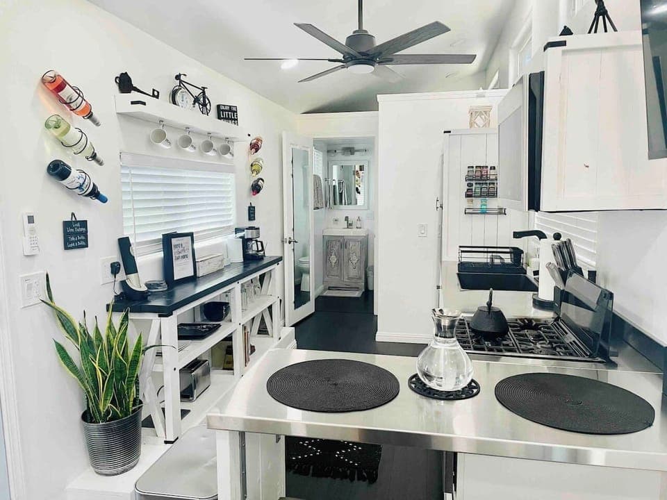 Ideal for quick meals or snacks, this charming kitchenette offers a compact stovetop, essential prep space, and clever storage solutions, including built-in wine and mug racks, ensuring all your needs are met in one functional space.