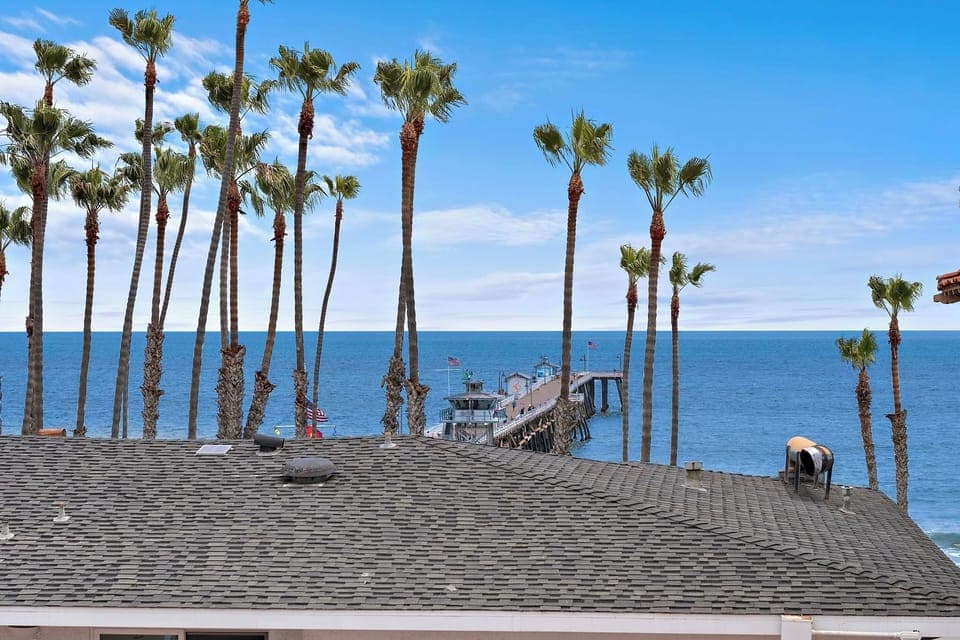New listing from hosts with 4.99 star cumulative rating!  The view is full of palm trees and a vast horizon. Gentle ocean breezes and the sounds of waves will remind you just how close you are to the pier and the beach.