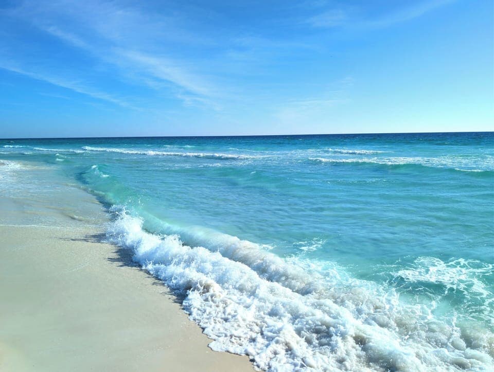 Oceanfront bliss: white-sand beach and turquoise waves steps away.