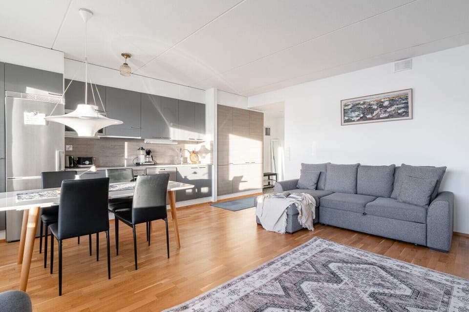 The open-plan living area combines a modern kitchen, dining space, and a cozy living room.