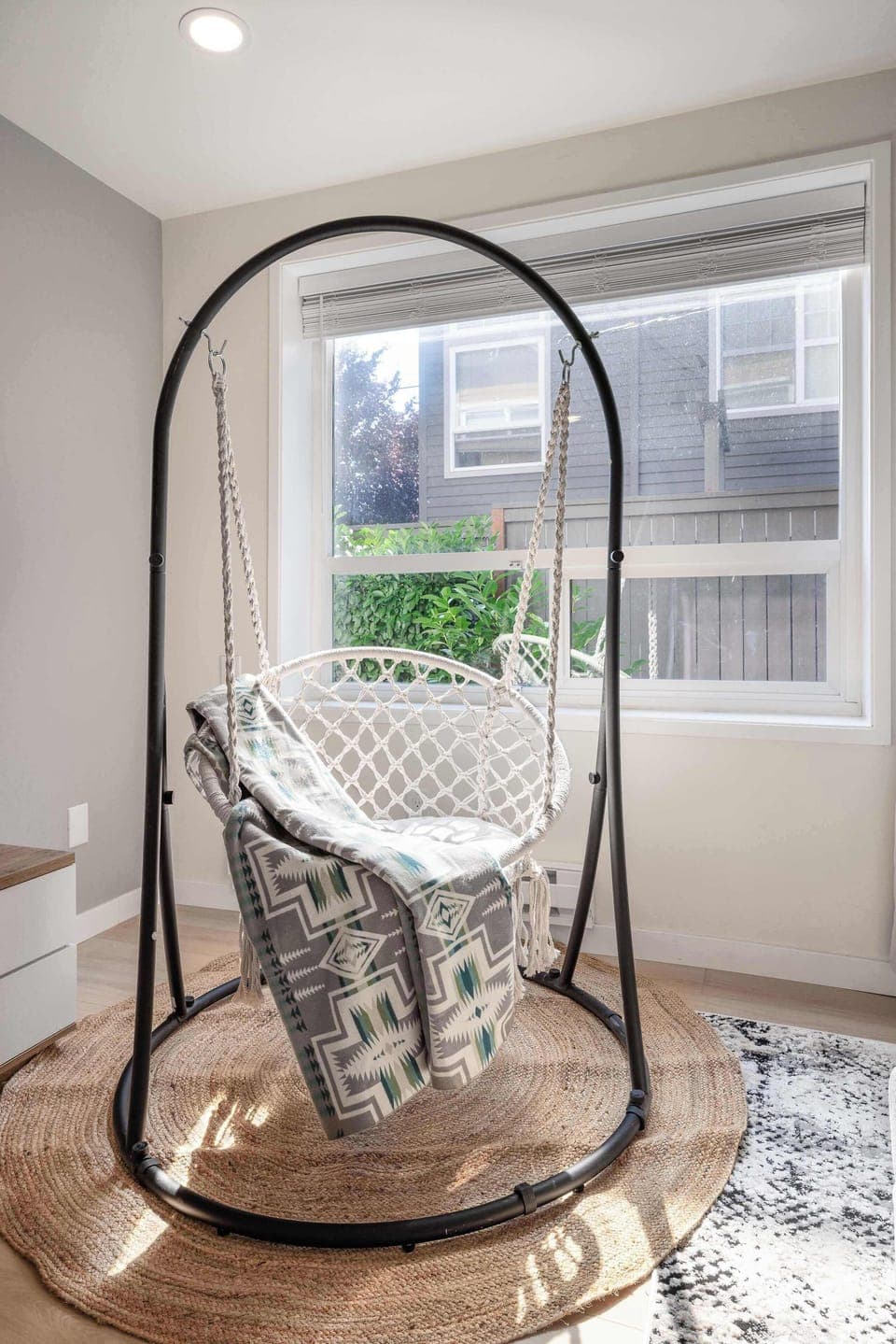 Bright living space with a hanging chair, perfect for relaxing in natural light.
