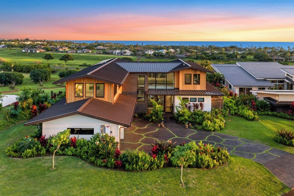 Your luxury home situated on pristine golf course with ocean views and tropical landscaping during golden hour.