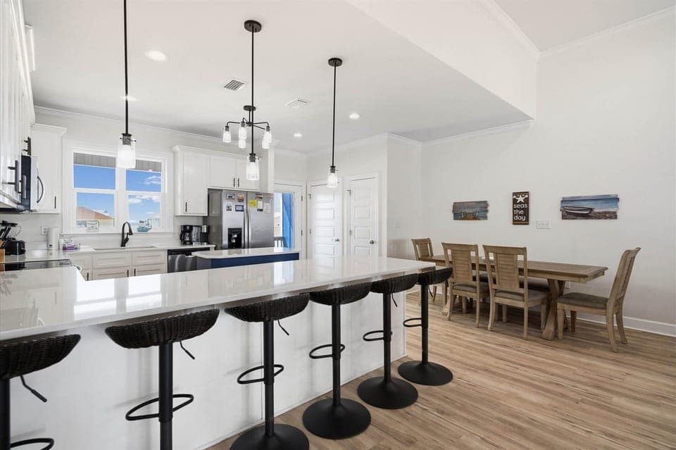 Your open kitchen flows seamlessly into the dining area, where modern pendant lights illuminate the spacious island perfect for morning coffee or evening meals together.