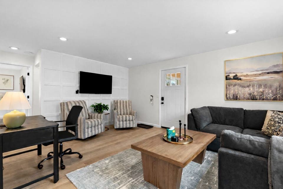 Enjoy this bright living room with comfortable seating, a smart TV, and a dedicated workspace—perfect for relaxing, working, or entertaining with ease.