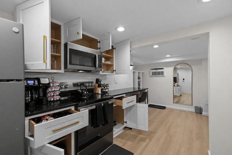 Fully equipped kitchen with modern appliances, ample counter space, and open shelving—ideal for cooking, coffee, and everyday convenience.