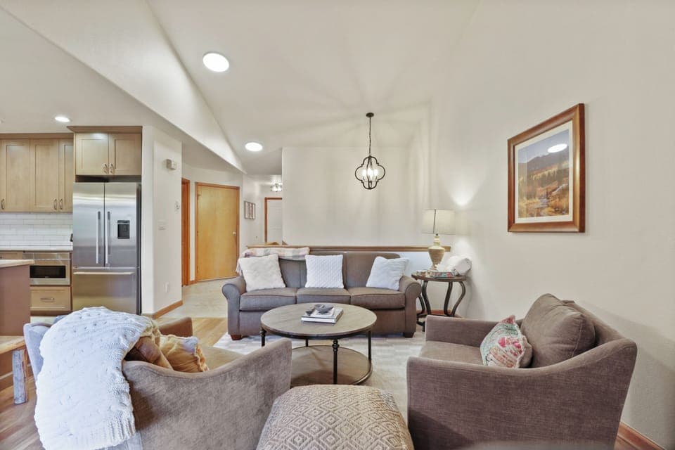 Sink into plush seating where natural light dances across warm wood floors, creating your perfect retreat.