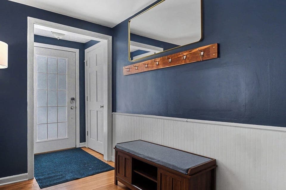 Main entryway greeted by a shoe rack/bench