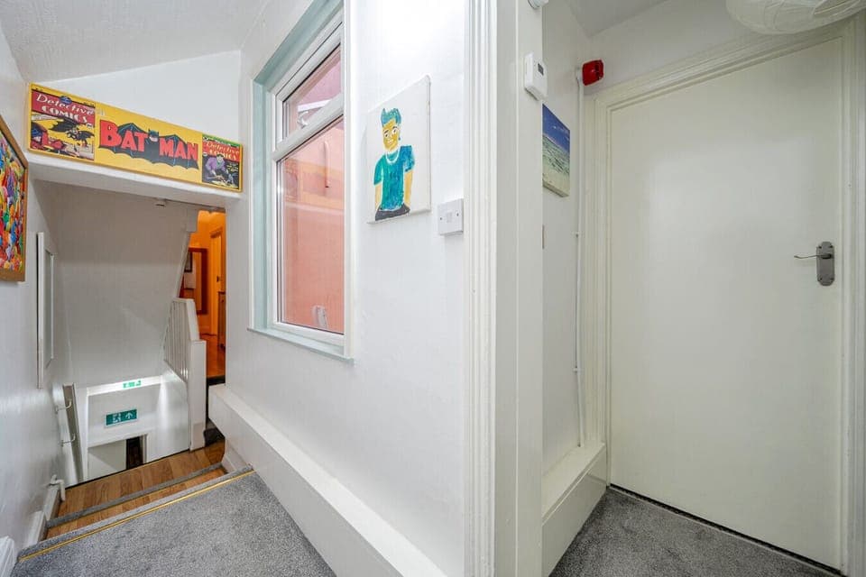 Stairwell landing with wall art and a small window bringing in daylight