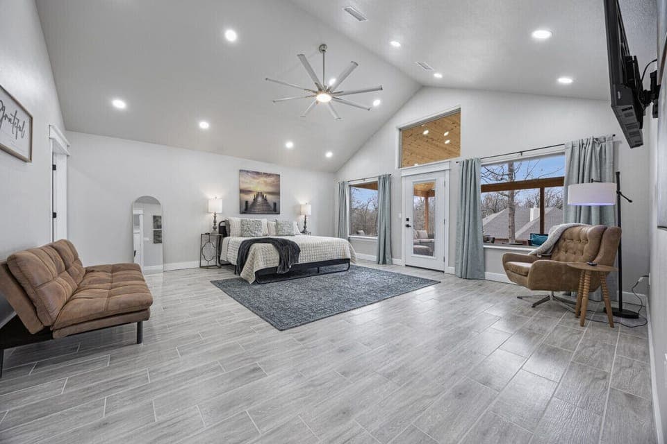 Primary bedroom with king bed, ensuite bathroom with shower, and access to the covered porch