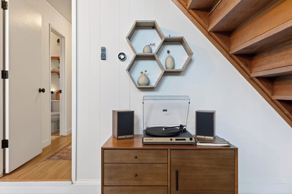 Dedicated music corner with a record player and geometric honeycomb shelving.