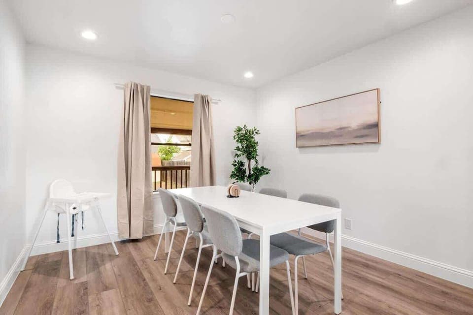 Dining area with seating for six plus a high chair for little ones. Modern design and natural light create the perfect setting for family dinners, game nights, or sharing meals before heading out to enjoy the city.