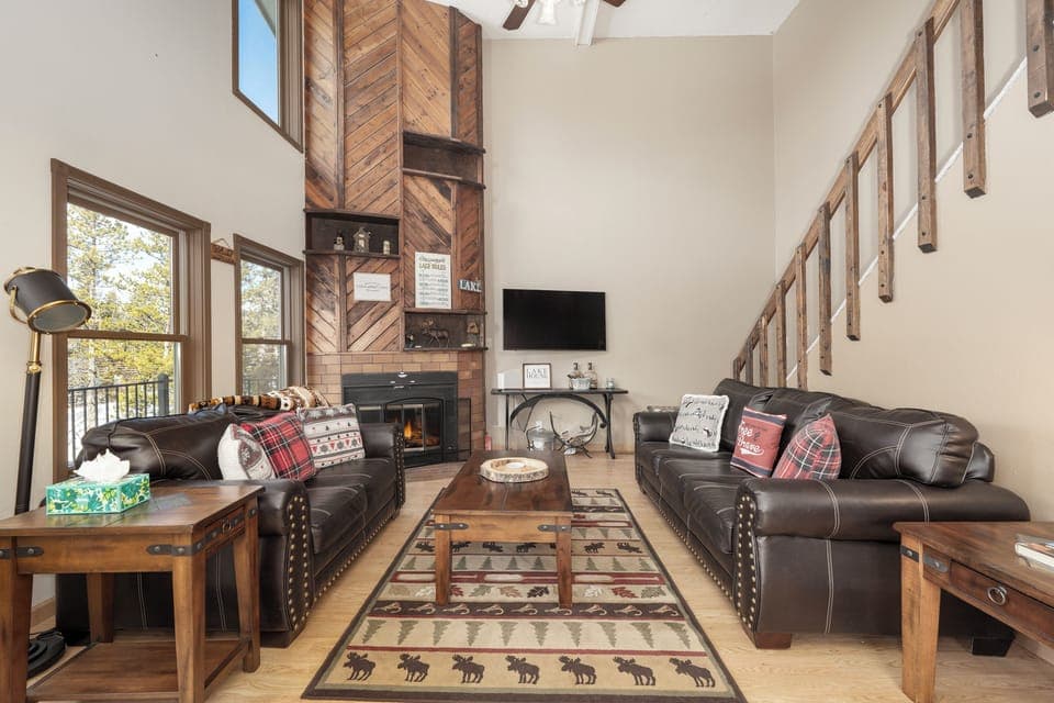 Sink into these plush leather sofas at 874 Kinnikinnick Road to enjoy your crackling fireplace, where rustic charm meets modern comfort in your mountain retreat.