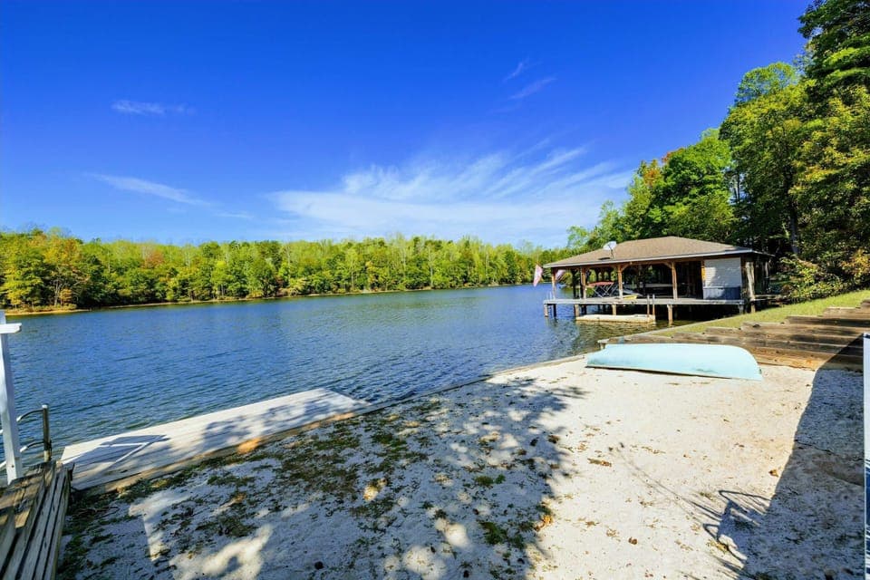 Sandy Beach - Private sandy beach area with kayaks and the boathouse in the background.