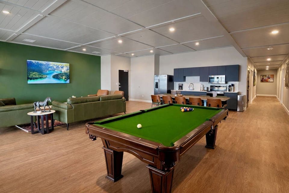 Challenge your friends to a game on the bright green felt pool table right in the massive open living space. A long olive green leather sofa is ready for your whole crew to hang out comfortably.