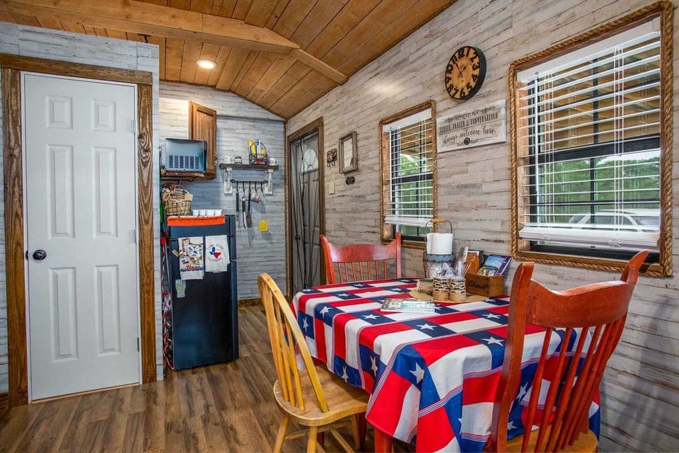 The functional dining and kitchenette area of the guest cabin is bright and efficient, featuring rope-trimmed windows and plenty of character.