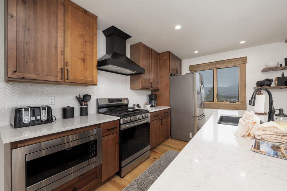Your fully equipped kitchen at 224 GCR 4034 awaits with warm wood cabinetry, stainless steel appliances, and everything you need to create memorable meals.