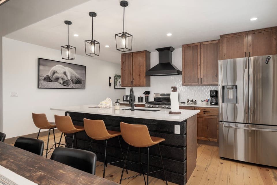 Cook and connect in this stunning modern kitchen featuring sleek appliances, spacious quartz countertops, and stylish seating for memorable meals together when you stay at 224 GCR 4034.