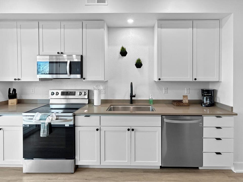 Your fully equipped kitchen features modern appliances and sleek white cabinetry, perfect for preparing meals during your stay.