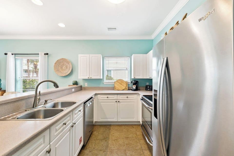Your fully-equipped kitchen awaits with modern appliances and soothing coastal colors, perfect for preparing meals during your stay.