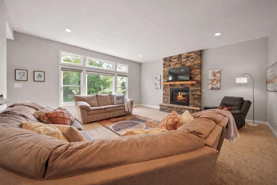 Bright living room w/ plush sectional seating & large windows filling the space w/ natural light