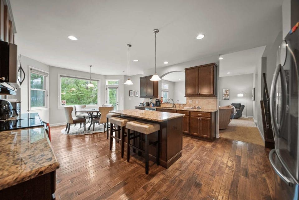 Open kitchen view w/ large island, bar seating & seamless flow into living areas