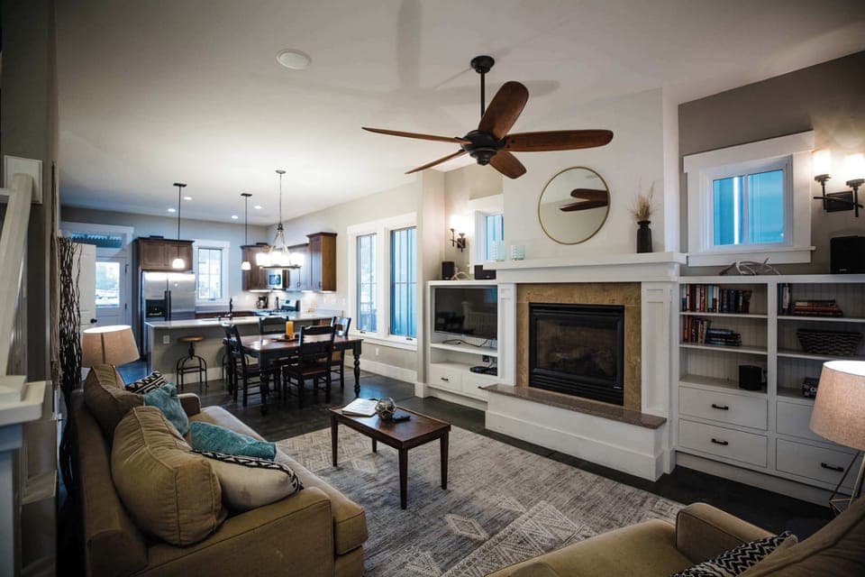 The living room centers around a classic gas fireplace framed by custom built-in cabinetry and shelving, with comfortable seating arranged for easy conversation and relaxed evenings in.