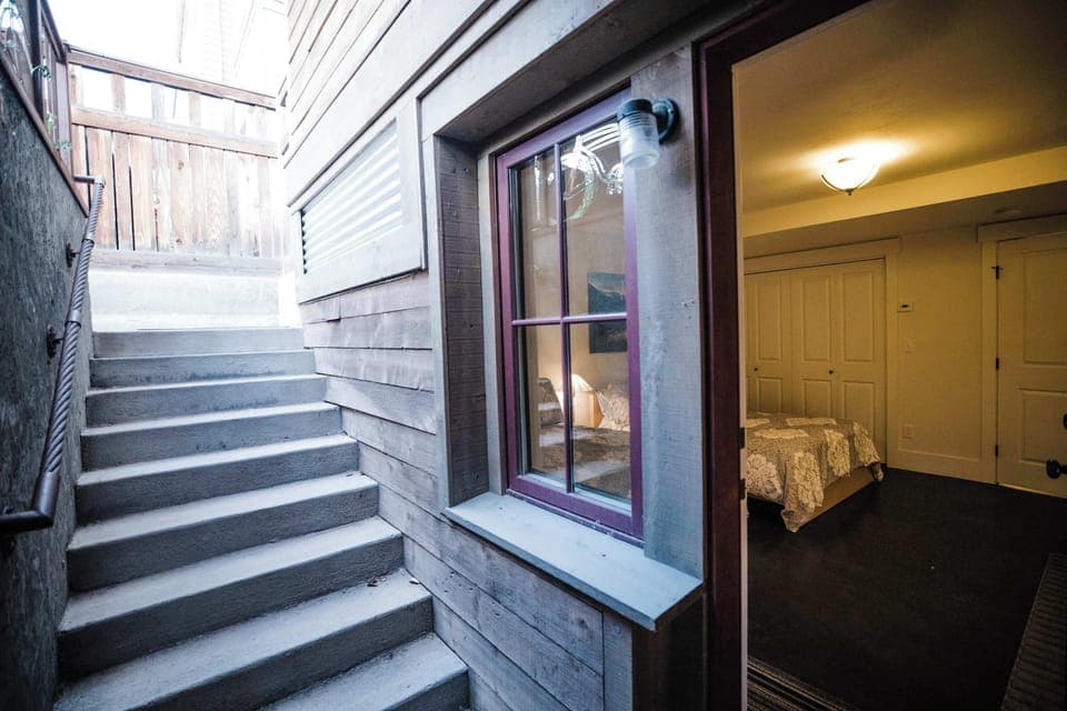 A private back entrance with a covered staircase provides direct access to the lower level, making it ideal for unloading outdoor gear without coming through the main living areas.
