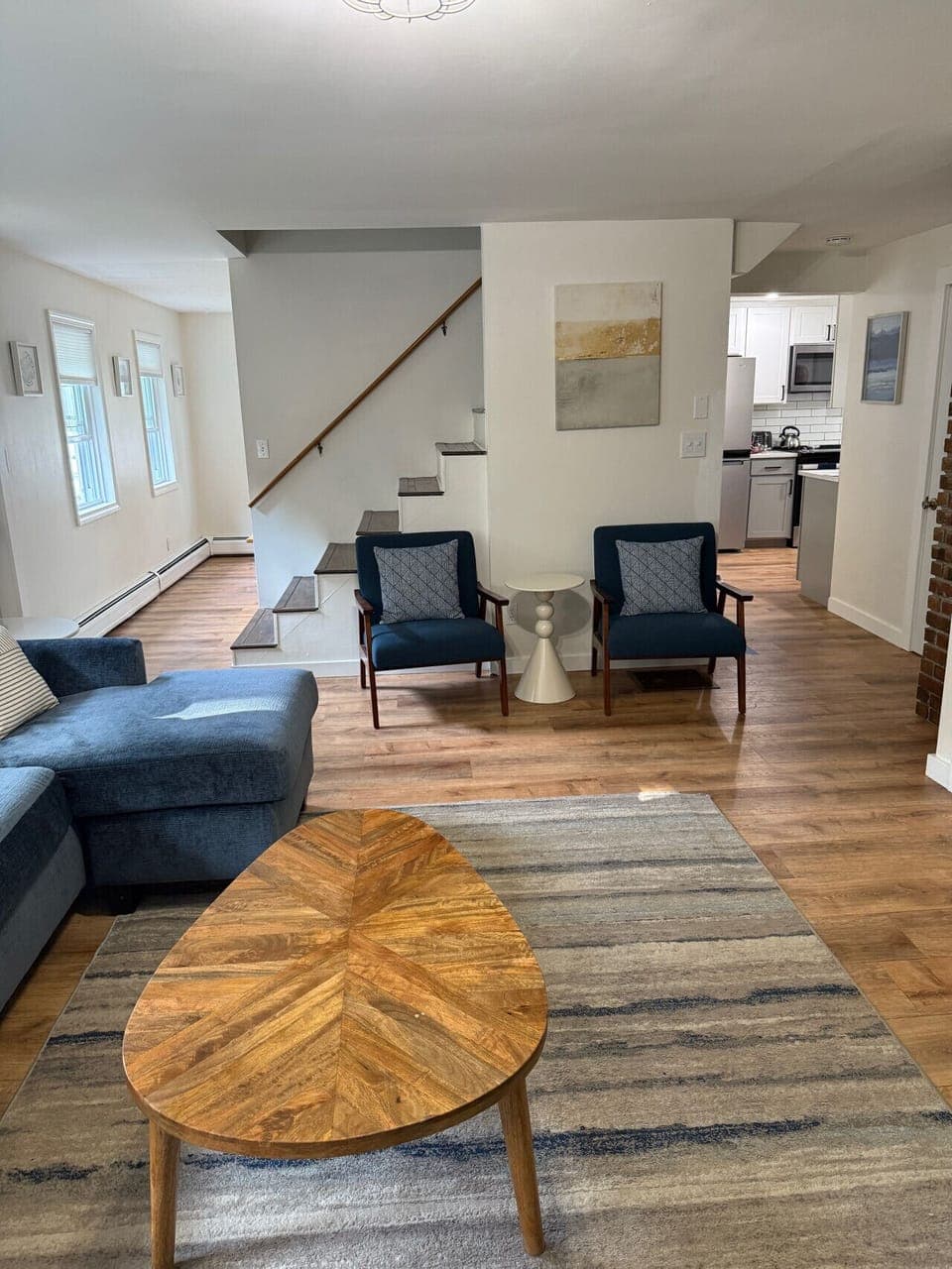 Spacious living area with a cozy sectional, modern décor, and an open flow into the kitchen