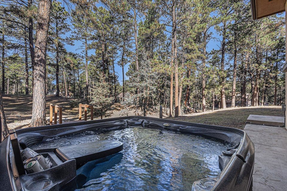 Slip into the hot tub and unwind beneath towering pines, where quiet forest views, fresh mountain air, and a soothing hot tub create the perfect spot to relax after a day of adventure.
