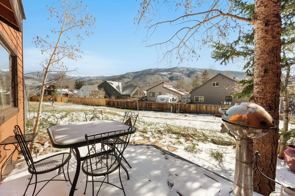 Back patio with outdoor seating, grill, and large shared backyard.