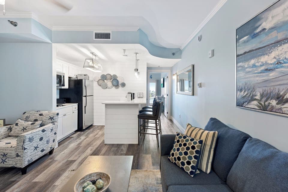 Sink into coastal comfort in your bright, open-concept space where soothing blues and beach artwork create your perfect seaside retreat.