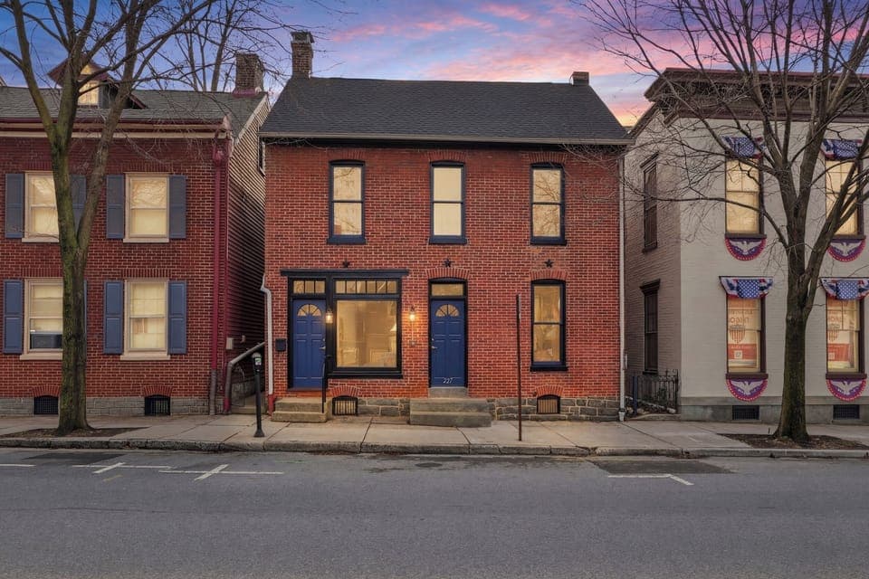 This is what 160 years of Gettysburg history looks like from the sidewalk — a classic brick façade, bold blue doors, and a sunset that feels like it was staged just for you.