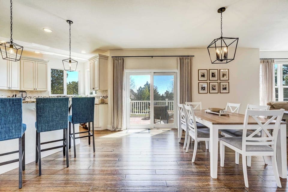 The main level flows from the kitchen island through the dining area and straight out to the deck, a layout that makes everything from casual breakfasts to group dinners feel natural and effortless.