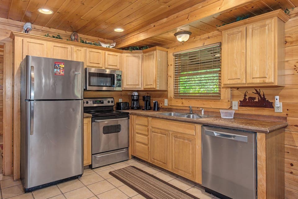 Your fully-equipped kitchen features stainless steel appliances and warm wood cabinetry, perfect for preparing meals during your mountain getaway.