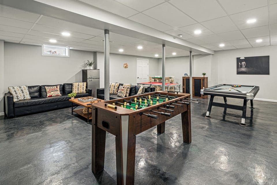 Fun basement rec room with foosball, pool, and a cozy lounge setup for games and laid‑back hangouts. (Laker's Pointe)