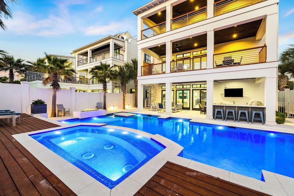 Modern luxury vacation home with stunning pool, spa, and tropical landscaping in an upscale neighborhood setting.