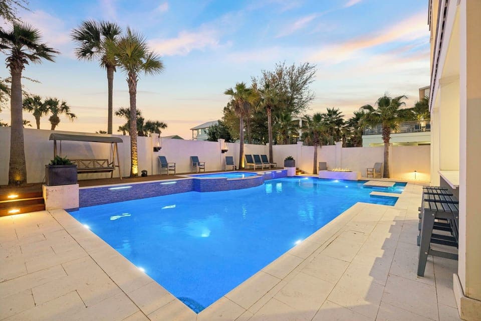 Unwind in your private tropical paradise as evening light dances across crystal-clear waters, surrounded by swaying palms and elegant poolside seating.