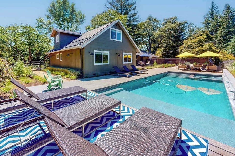Dive into your Sonoma wine country escape — a sparkling private pool flanked by striped loungers awaits after a day exploring nearby tasting rooms.