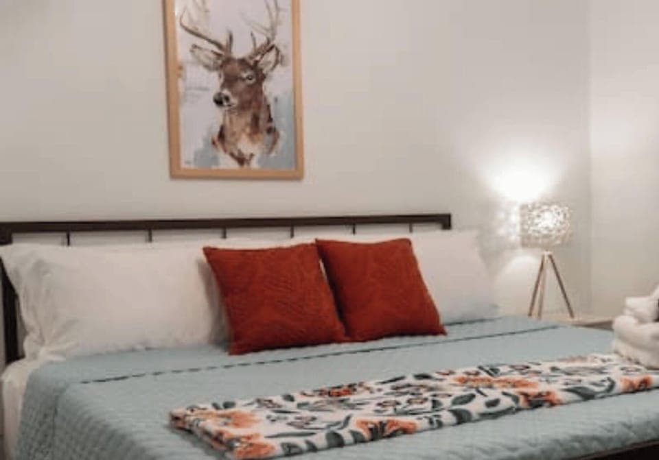 King bed in the main room with deer decor for our backyard friends!