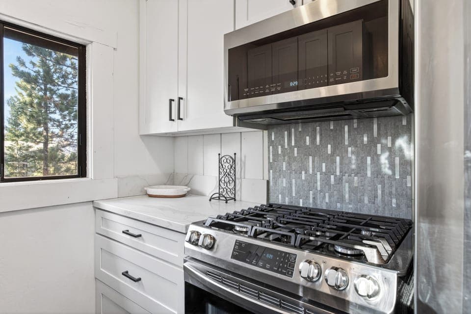 Fully equipped kitchen featuring a high-end gas range and modern backsplash.