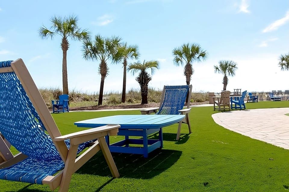 Lounge on vibrant lawns with palm shade and sea air.