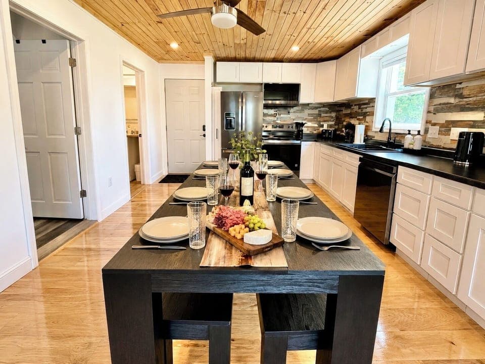Gather around this warm, modern kitchen featuring beautiful wood ceilings, updated appliances, and plenty of space to cook, dine, and make memories together.