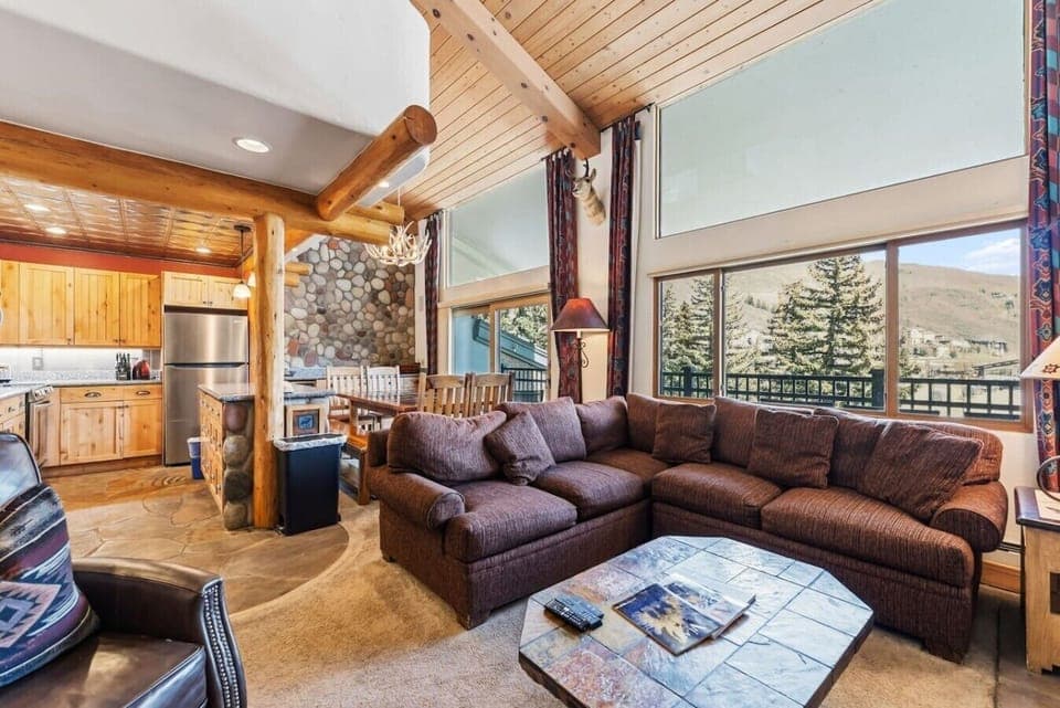 Spacious living room with vaulted ceiling, smart TV, fireplace, and fantastic views