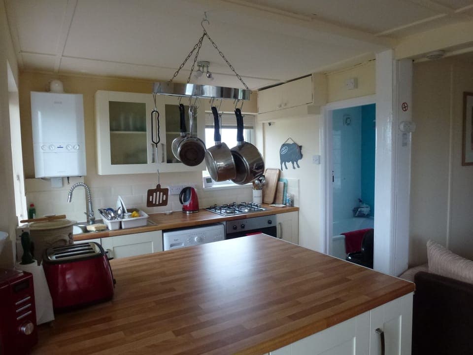 kitchen area showing washing machine, other useful small appliances and bathroom